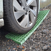 Car wheel on a green ramp on a waffle board gravel surface