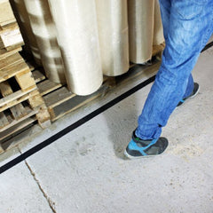 Heavy-duty black aisle marking tape applied on warehouse floor for safety and organization