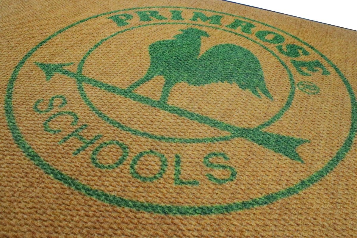 close up of Logo of Primrose Schools on a textured surface with green text and rooster silhouette.
