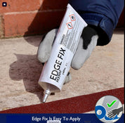 Hand holding a tube of 'Edge Fix' sealant against a brick wall background