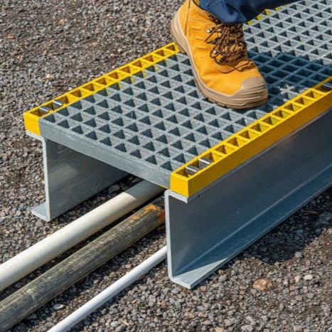 Person using a GRP Platform with yellow edges on a gravel surface