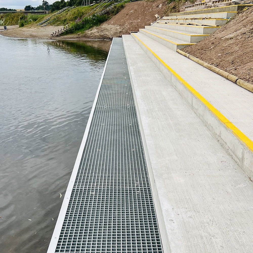 GRP mesh walkway with metal grate next to a body of water