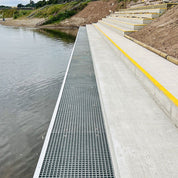 GRP mesh walkway with metal grate next to a body of water