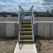 GRP Staircase with yellow steps and metal railing on a construction site