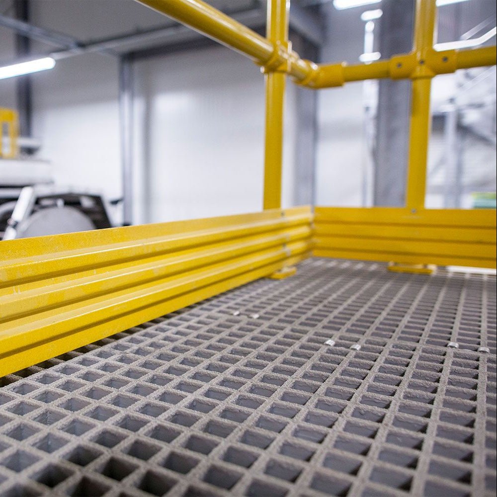 Yellow GRP mesh grating frame with a grid-like surface in an industrial setting