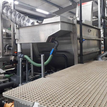 Industrial setting with a large GRP panels shets and machinery in an indoor facility.