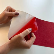 Person peeling a red anti slip tape