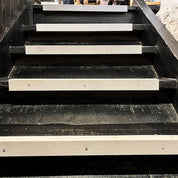 Black wooden staircase with white risers in an urban setting