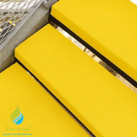 Yellow stair treads with a non-slip solution on a staircase.