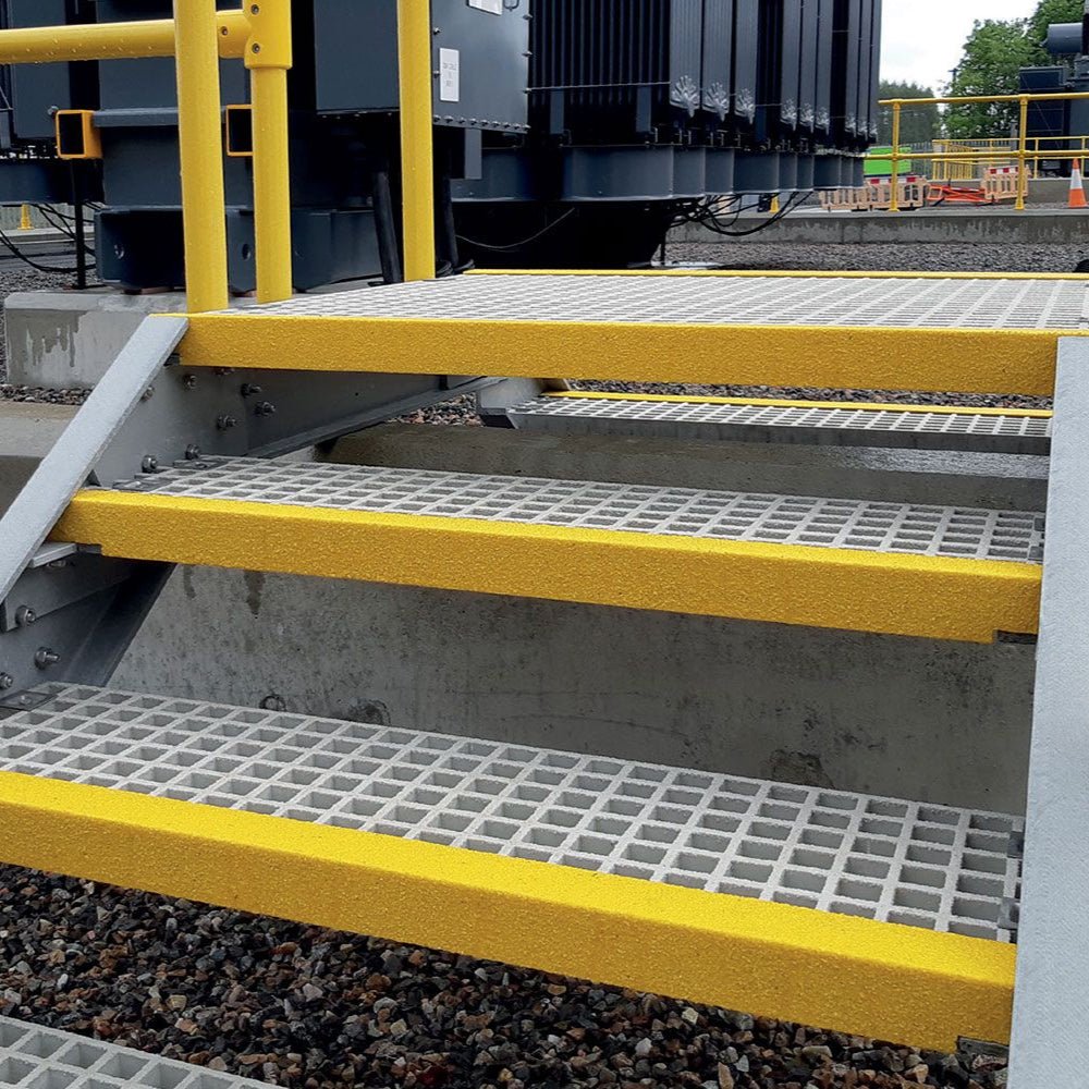 Metal staircase with yellow handrails and steps in an industrial setting